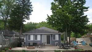 A house with a dock extending into a body of water, surrounded by trees and a fenced yard. - All Sports Lake / Golf, minutes from many players (Lapeer)