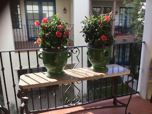 Enjoy the serene garden views from this balcony with a bathtub and comfortable seating.