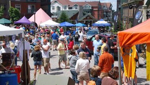 Un marché animé en plein air, avec de nombreux stands et tentes.