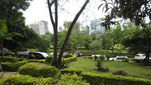 A park with manicured lawns, trees, and parked cars. - Furnished Studio Apartments at YWCA Parkview Suites ,Nairobi(YWCA OF KENYA) (Nairobi)