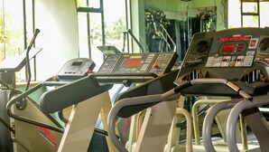 A row of treadmills in a gym with control panels and a window in the background. - Furnished Studio Apartments at YWCA Parkview Suites ,Nairobi(YWCA OF KENYA) (Nairobi)