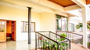 A spacious interior with a staircase, a wooden ceiling, and a balcony with potted plants. - Furnished Studio Apartments at YWCA Parkview Suites ,Nairobi(YWCA OF KENYA) (Nairobi)