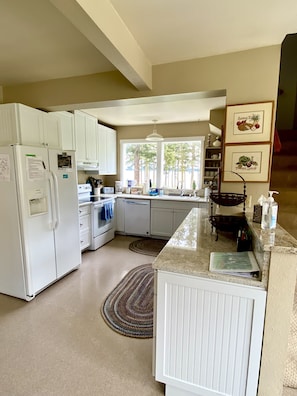 Enjoy cooking in this well-equipped kitchen with oven, refrigerator, and sink.