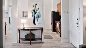 Una cocina moderna con armarios de madera, un refrigerador y un comedor con mesa y sillas.