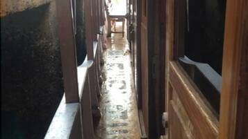 A narrow corridor with wooden walls and a metal railing on one side.