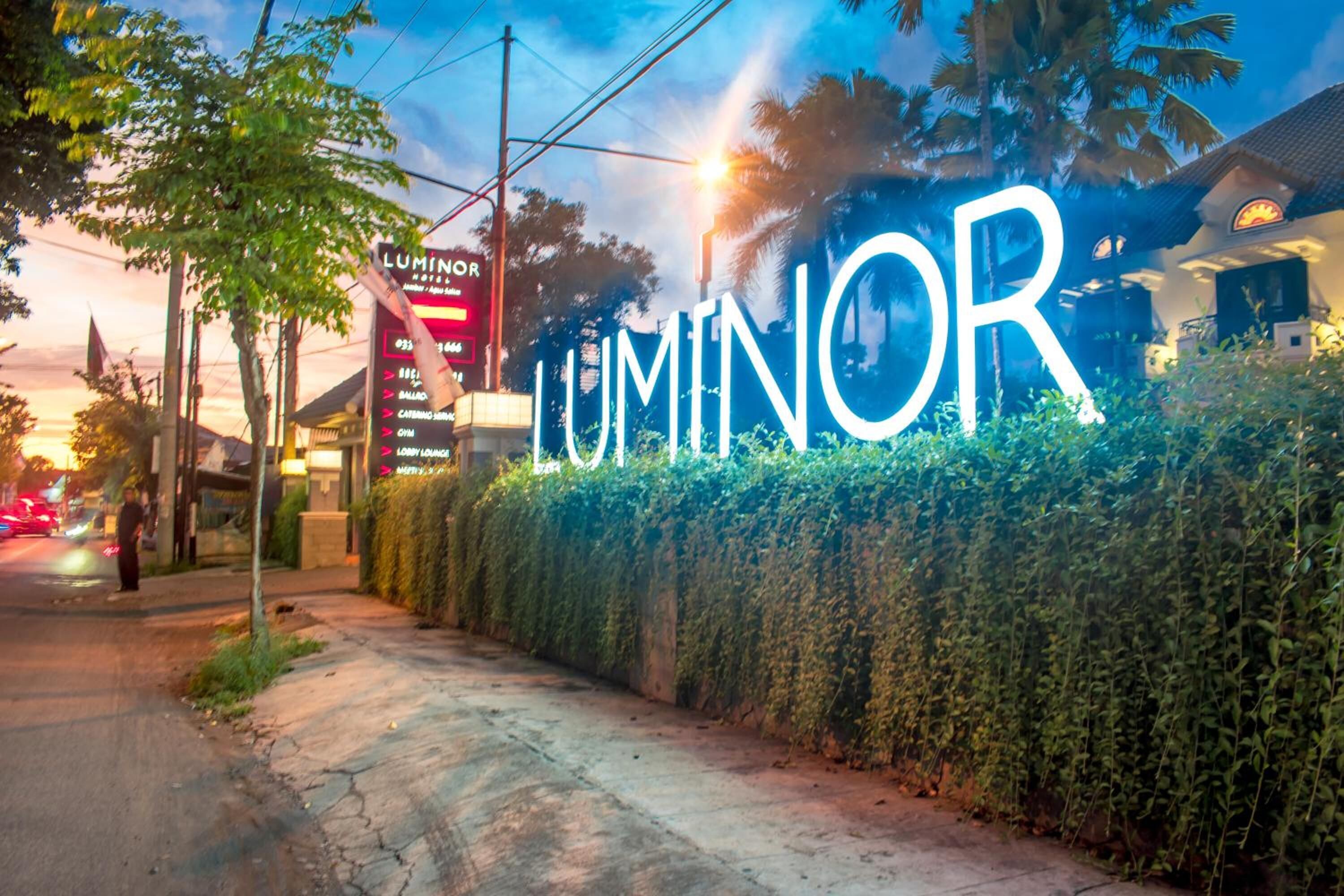 A hotel sign with the name 'LUMINOR' illuminated in white letters.