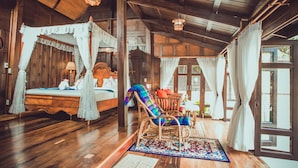 A wooden bedroom with a four-poster bed, a daybed, and a rocking chair. - Sasitara   Thai  villas (Koh Samui)