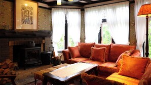 Una sala de estar acogedora con chimenea, un conjunto de sofás y una mesa.