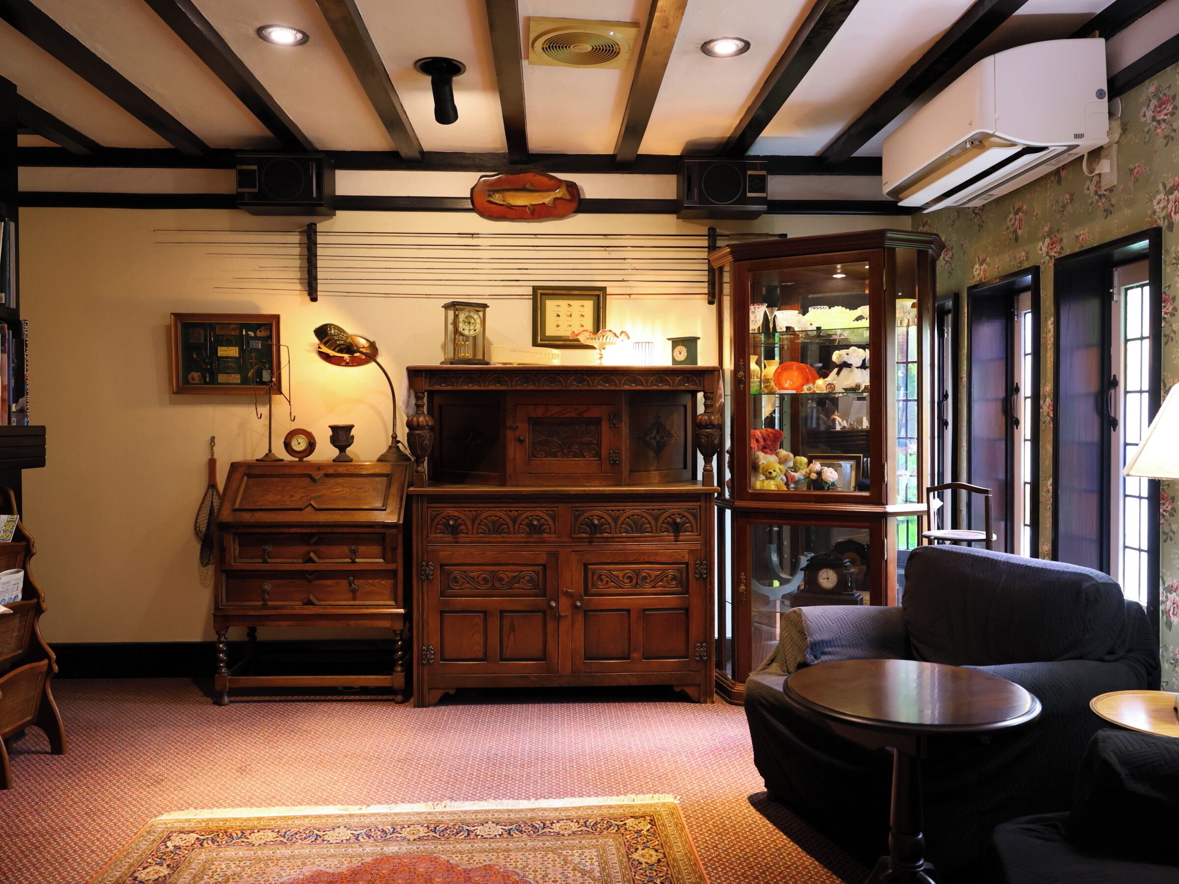 A traditional room with a wooden cabinet, a small table, a sofa, and a patterned rug.