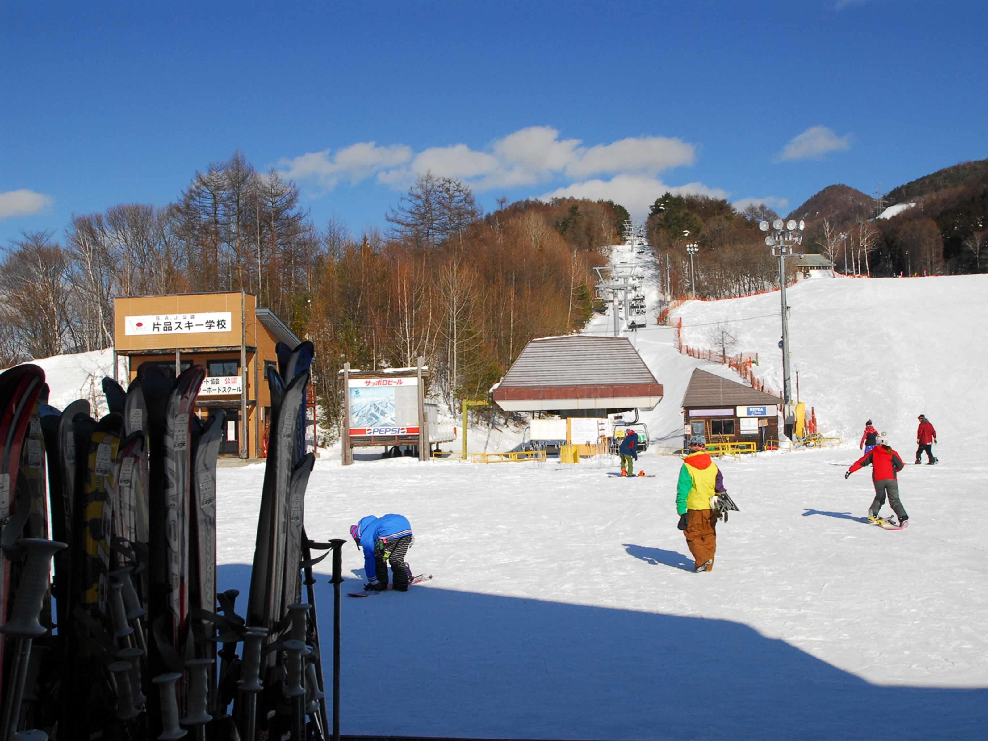 A ski resort with ski equipment, a ski lift, and a building with signage.