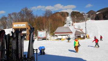 A ski resort with ski equipment, a ski lift, and a building with signage.