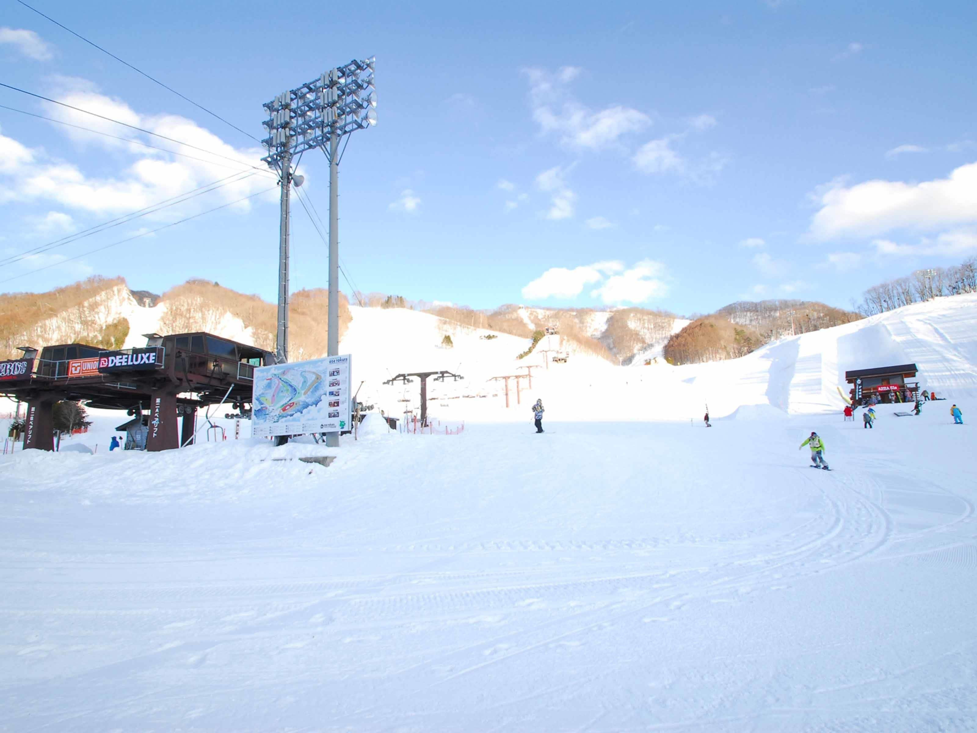 A ski resort with a lift station, ski lift, and a snow-covered slope.