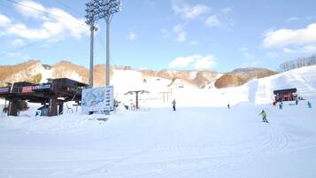 A ski resort with a lift station, ski lift, and a snow-covered slope.