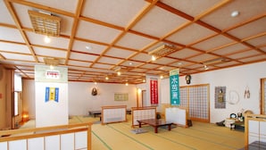 A traditional tatami mat room with wooden beams, tatami mats, and shoji screens.