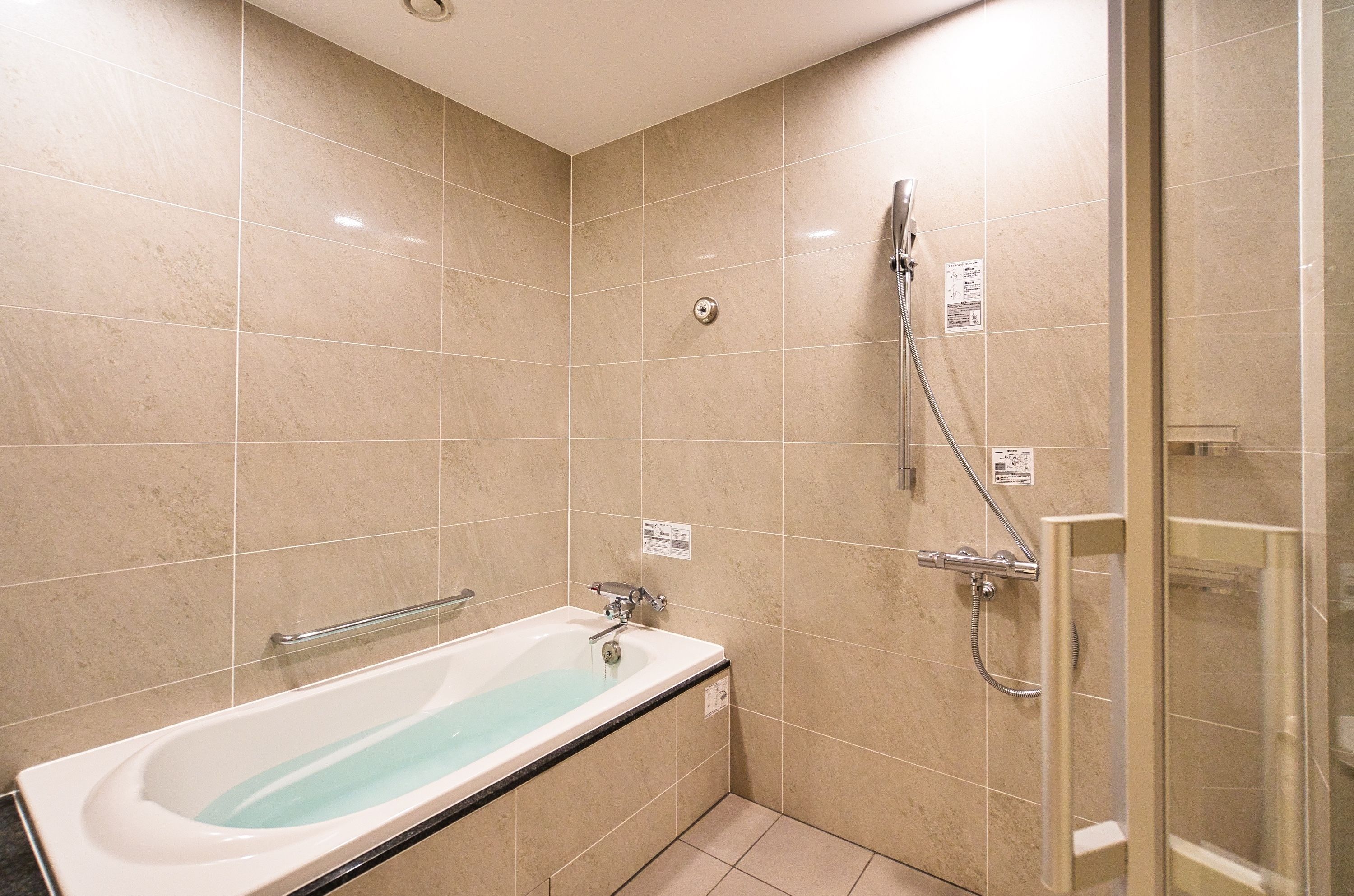 Een badkamer met een badkuip, een douche en een glazen douchecabine.