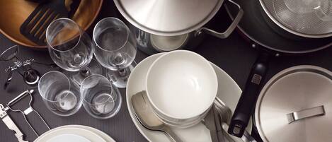 A kitchen with various utensils, pots, and glasses.