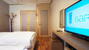 A hotel room with two beds, a desk with a computer, and a TV displaying the word "BARCO". - Raum Hotel (Jeju City)