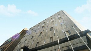 A tall, modern building with a grid of windows and a prominent "HOTEL" sign on the facade. - Raum Hotel (Jeju City)