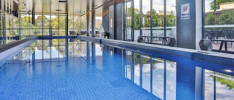 Una piscina techada, sillones reclinables de piscina