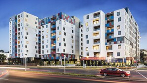 A modern multi-story hotel with a distinctive facade featuring geometric patterns and balconies. - Melbourne Knox Central Apartment Hotel (Wantirna South)