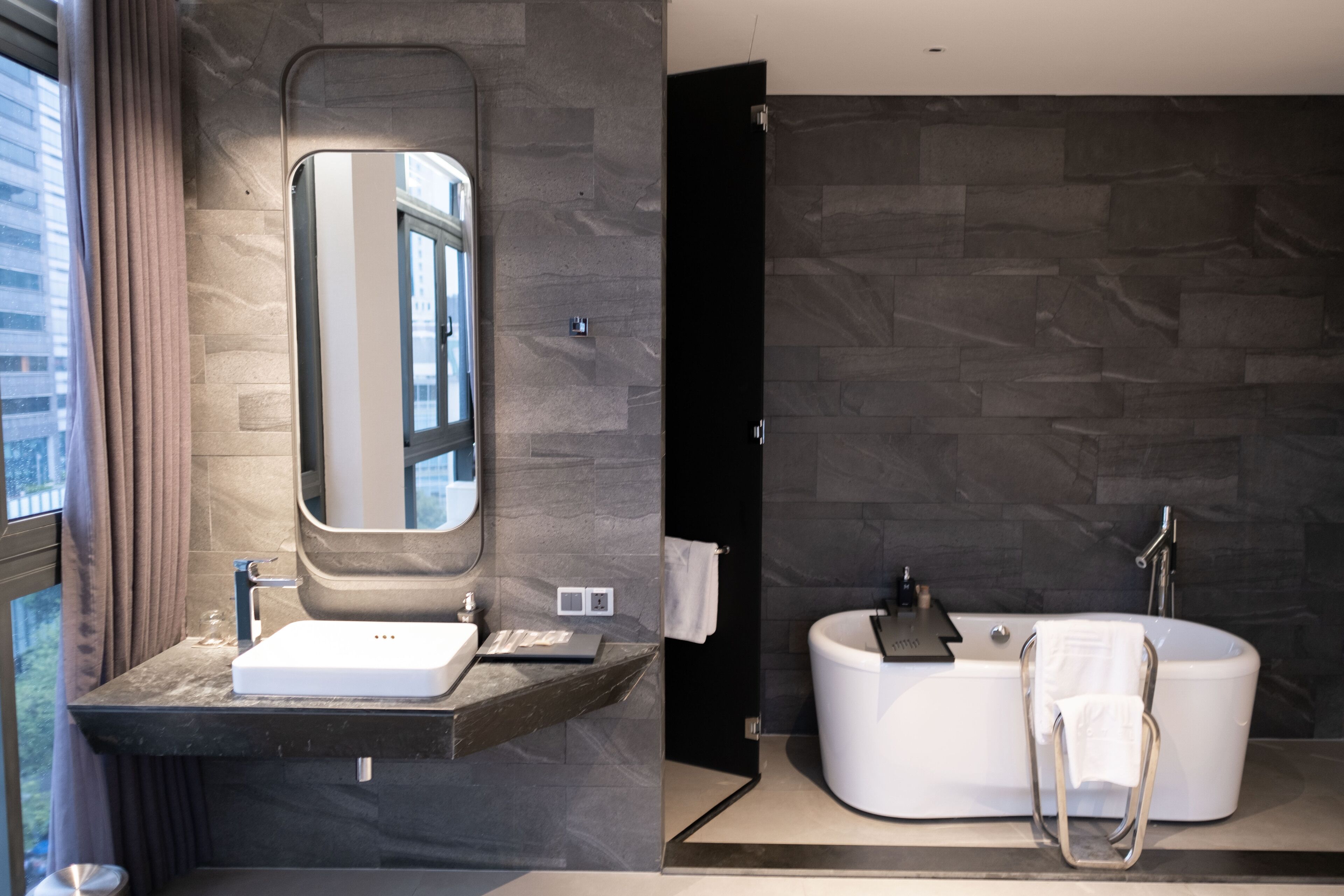 contemporary suite | bathroom | designer toiletries, hair dryer, slippers, towels