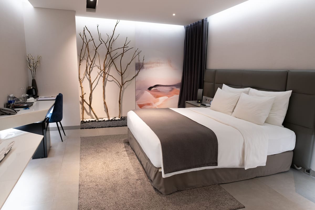 A modern bedroom with a bed, desk, and chair.