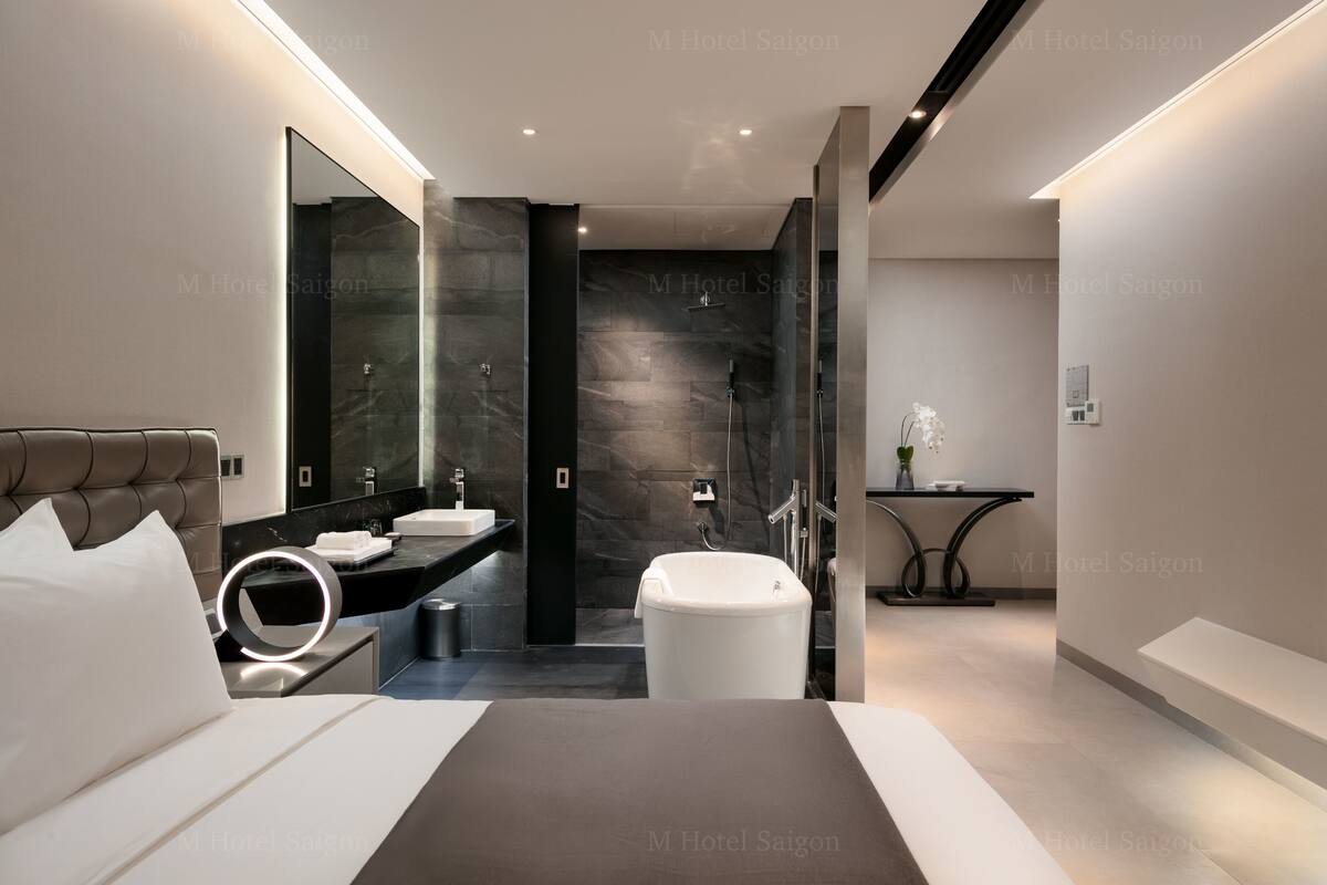 A modern hotel bathroom with a large bathtub, a separate shower area, and a vanity with a mirror.