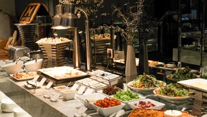 Un bufé con diferentes opciones de comida y un letrero que indica un hotel.