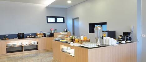 A modern kitchen with a central island, equipped with various appliances and food items.
