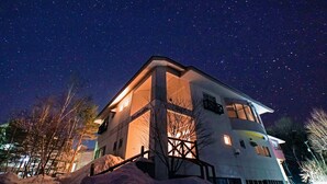 A modern building with a large balcony and a starry night sky. - Pension Entre - deux - Mers (Hachimantai)