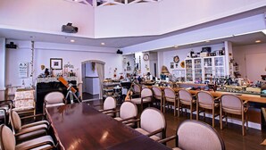 A spacious, well-lit room with a long wooden table and multiple chairs, a bar area with various items, and a loft space above. - Pension Entre - deux - Mers (Hachimantai)