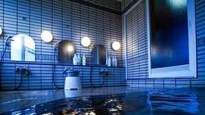 A modern bathroom with a large bathtub, built-in mirrors, and a tiled floor. - Pension Entre - deux - Mers (Hachimantai)