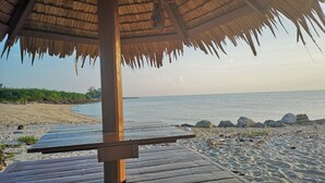 A wooden deck leading to a beach with a thatched roof structure. - Veepana Resort (Ban Laem)