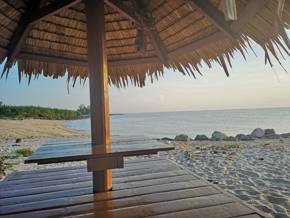 A wooden deck leading to a beach with a thatched roof structure. - Veepana Resort (Ban Laem)