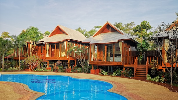 A resort with wooden cabins, a swimming pool, and lush greenery. - Veepana Resort (Ban Laem)