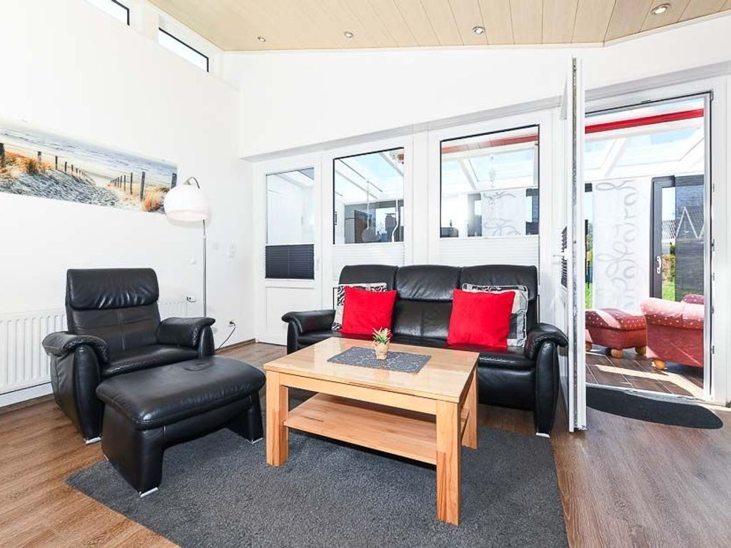 A modern living room with a sofa, armchair, and coffee table.