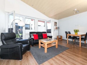 En moderne stue med sofa, sofabord og spiseplads.