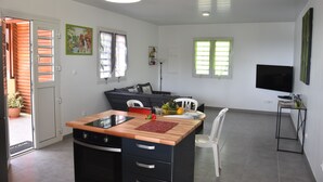 A modern kitchen with a wooden countertop, a built-in oven, and a dining area with a table and chairs. - TOP OF VILLA IN ITS VERY GREEN (sainte marie)