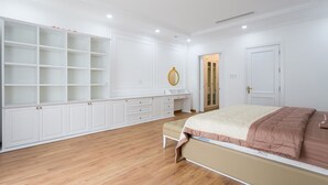 A bedroom with a large wardrobe, a bedside table, and a bed with a pink blanket. - TOP#1 Experience Danang 'Casa de Tan 1' Pool Villa (Da Nang)