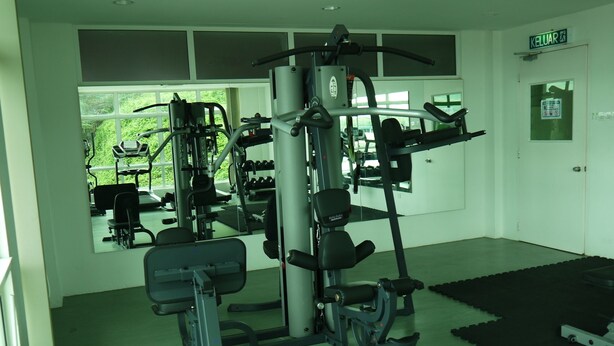 A gym with various exercise machines, a large mirror, and a door labeled "KELUAR". - Bosco Homestay (Kota Kinabalu)