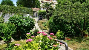 Un jardín con un sendero que lleva a un edificio con varios balcones.