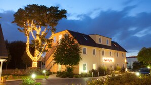 Un hotel con un letrero que dice "meinHotel" y un árbol decorado con luces.