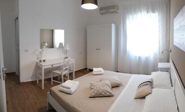 Escritorio, cortinas opacas, tabla de planchar con plancha