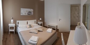 Escritorio, cortinas opacas, tabla de planchar con plancha