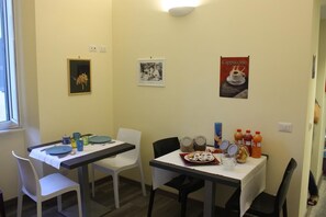 A dining area with two tables, chairs, and various food items. - B&B Holidays in Rome (Rome)