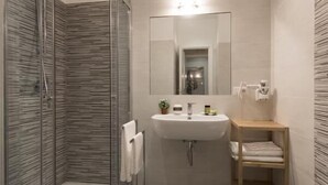 Une salle de bain moderne avec une douche à parois de verre, un lavabo avec un miroir et une baignoire sur pieds.