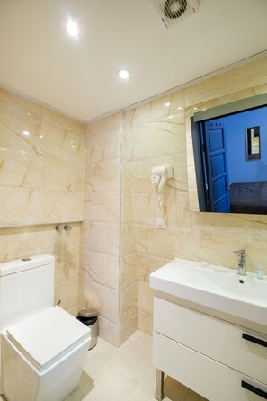 Un baño con inodoro, lavabo y espejo.