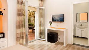 Une salle de bain moderne avec un lavabo, un miroir et un téléviseur fixé au mur.