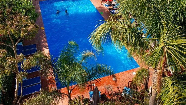 Une piscine avec vue sur la mer et une montagne en arrière-plan.