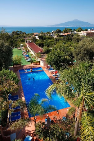 Una piscina al aire libre de temporada, sombrillas